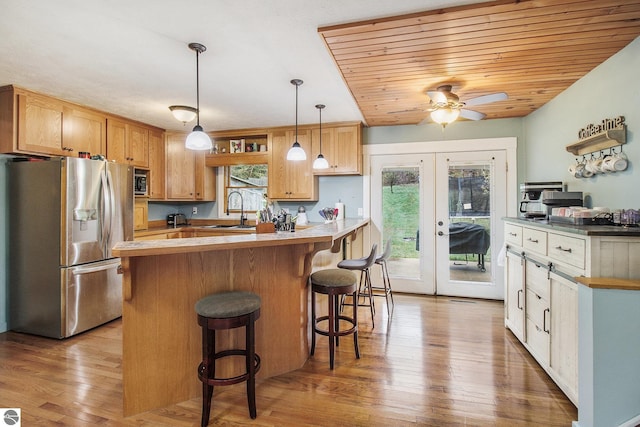 7809 Potter Rd, Bear Lake, MI 49614 - kitchen featuring a ceiling fan, french doors, a sink, a kitchen bar, and appliances with stainless steel finishes