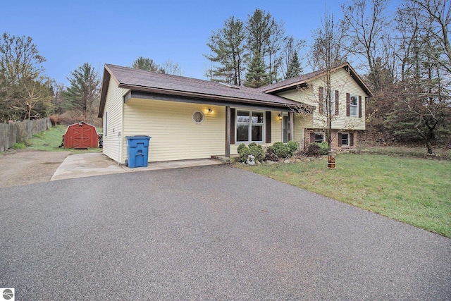 7809 Potter Rd, Bear Lake, MI 49614 - tri-level home featuring fence, a storage shed, a front lawn, and an outdoor structure