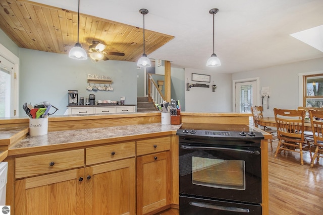 7809 Potter Rd, Bear Lake, MI 49614 - kitchen featuring light wood finished floors, tile counters, electric range, ceiling fan, and decorative light fixtures