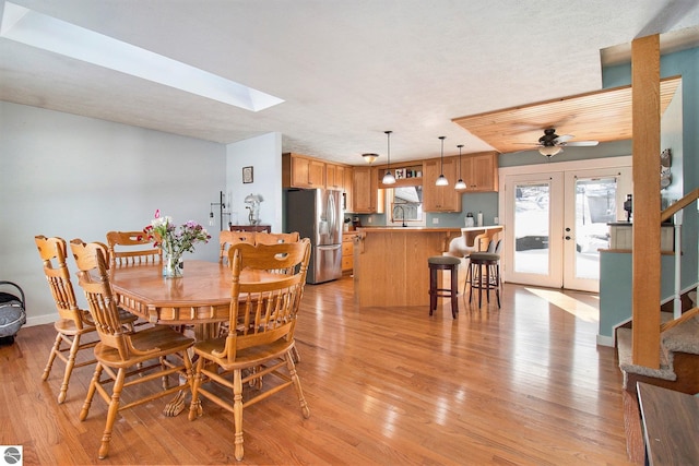 7809 Potter Rd, Bear Lake, MI 49614 - dining room with a skylight, french doors, stairway, a ceiling fan, and light wood-style floors