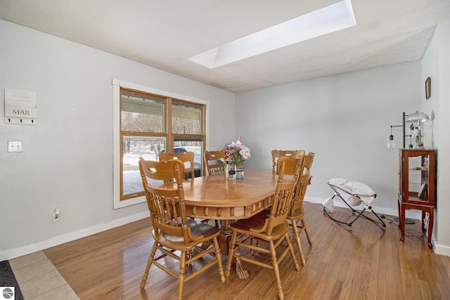 7809 Potter Rd, Bear Lake, MI 49614 - dining space with a skylight, baseboards, and light wood-style floors