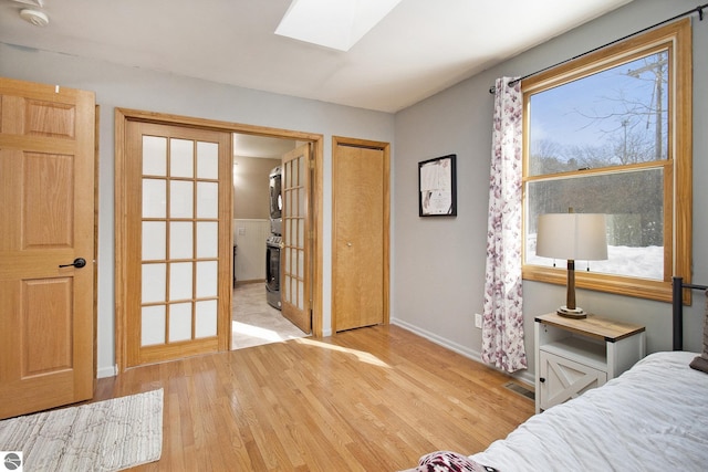 7809 Potter Rd, Bear Lake, MI 49614 - bedroom with french doors, baseboards, visible vents, light wood-style floors, and a skylight