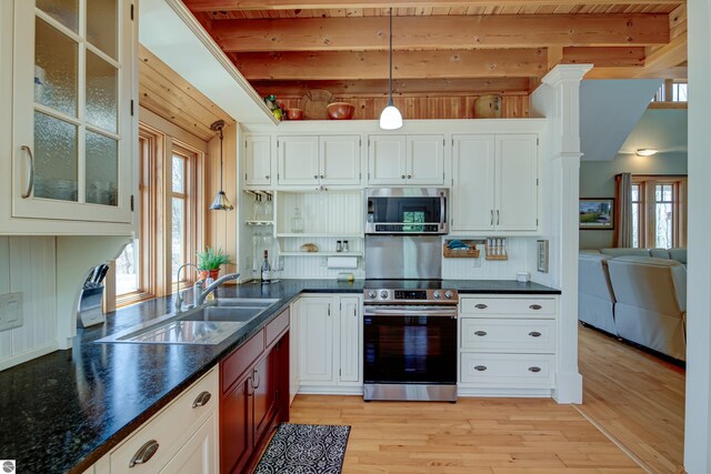 4130 W Dodge Springs Trl, Maple City, MI 49664 - kitchen featuring independent washer and dryer, appliances with stainless steel finishes, beam ceiling, and light wood-style floors