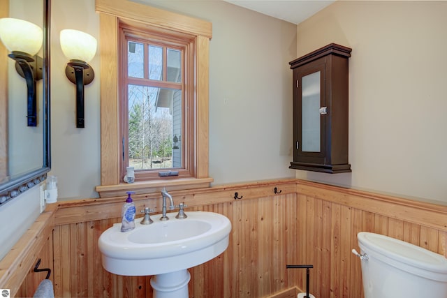 4130 W Dodge Springs Trl, Maple City, MI 49664 - bathroom featuring toilet, a healthy amount of sunlight, wainscoting, and wood walls