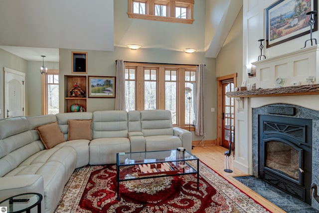 4130 W Dodge Springs Trl, Maple City, MI 49664 - living area with baseboards, light wood-style flooring, a fireplace with flush hearth, and a high ceiling