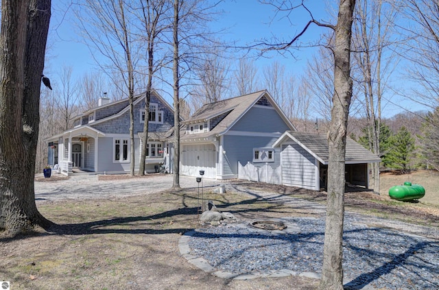 4130 W Dodge Springs Trl, Maple City, MI 49664 - view of front facade featuring a chimney, a porch, and a garage