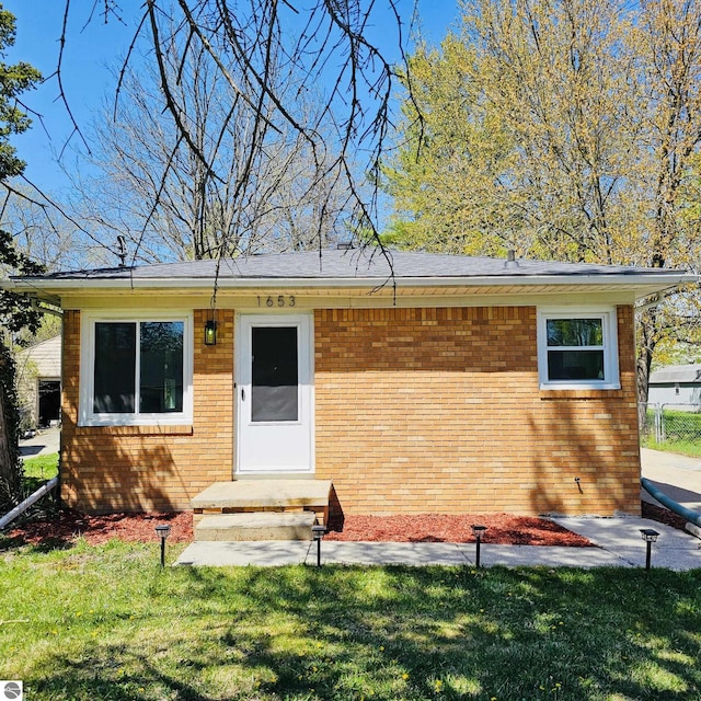 ranch-style home with a front lawn and brick siding