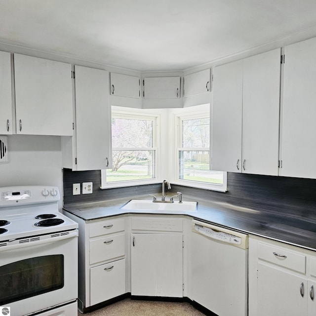 kitchen with white cabinetry, a sink, and white appliances