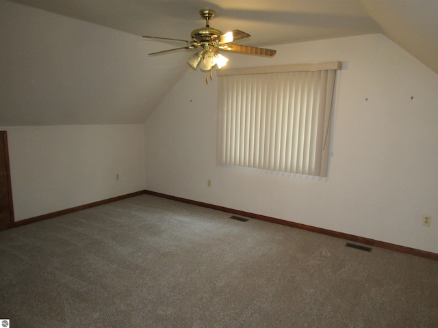 additional living space with carpet flooring, vaulted ceiling, visible vents, and ceiling fan