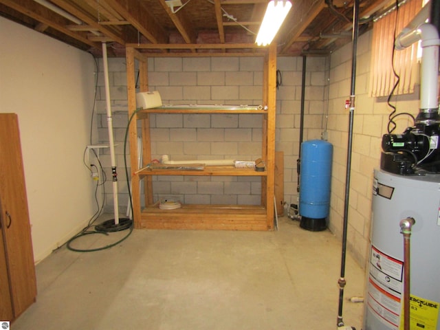 unfinished below grade area with gas water heater and concrete block wall
