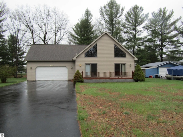 view of front of house featuring aphalt driveway, a deck, an attached garage, and a front yard