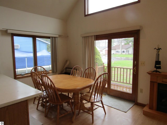 dining room featuring light wood-type flooring and high vaulted ceiling