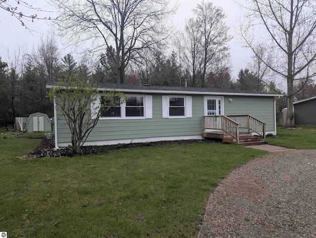 manufactured / mobile home featuring an outdoor structure, a shed, and a front yard