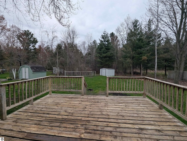 deck with a lawn, an outbuilding, and a storage unit