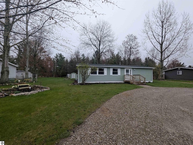 manufactured / mobile home with a front yard and gravel driveway