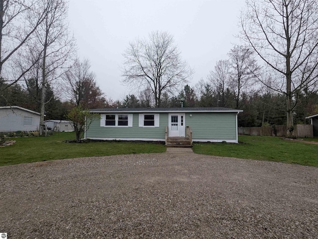 manufactured / mobile home featuring a front lawn and fence