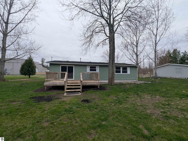 rear view of property with a yard and a wooden deck