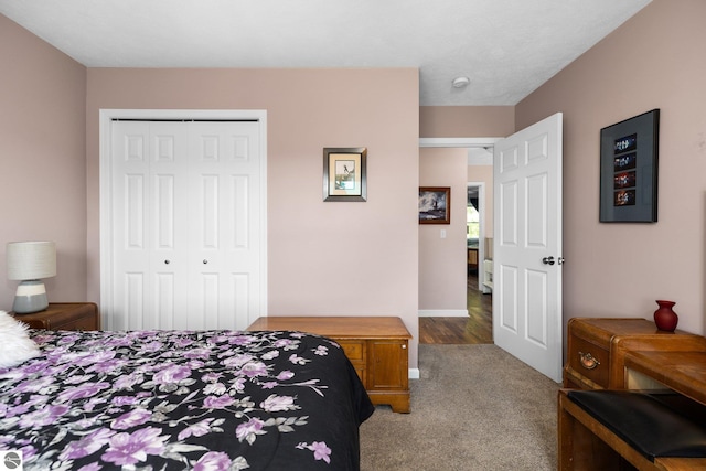 carpeted bedroom with baseboards and a closet