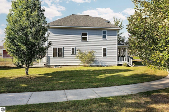 exterior space featuring a yard and roof with shingles