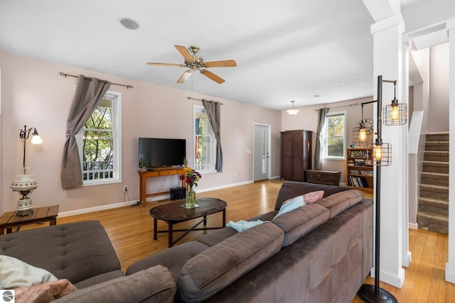 living area featuring a ceiling fan, stairway, and light wood-type flooring
