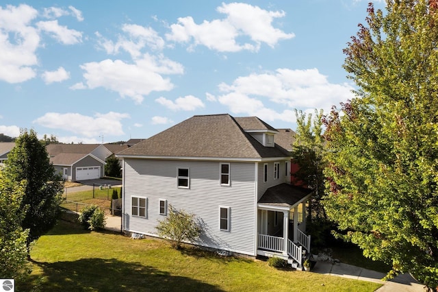 back of house featuring a shingled roof, a yard, and fence