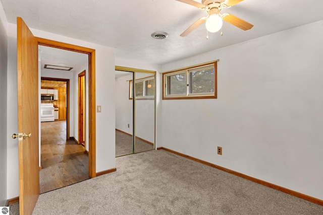 unfurnished bedroom featuring a closet, visible vents, carpet flooring, a ceiling fan, and baseboards