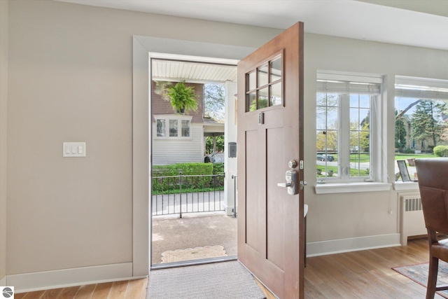 entryway featuring radiator, baseboards, and wood finished floors