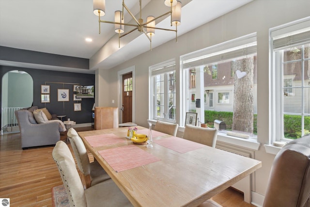 dining room featuring recessed lighting, light wood-style floors, arched walkways, and a notable chandelier