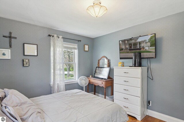 bedroom with baseboards and wood finished floors