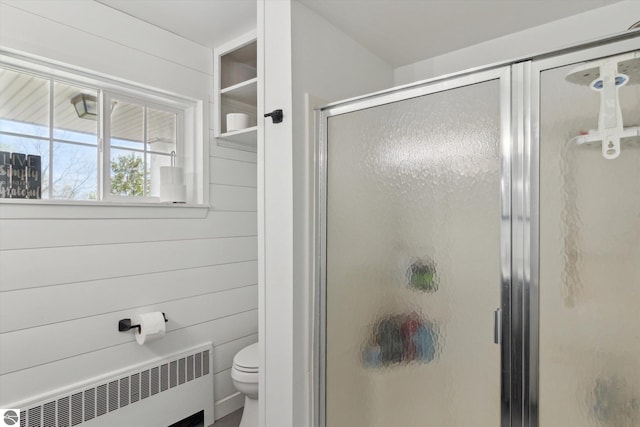 full bathroom featuring toilet, radiator, and a stall shower