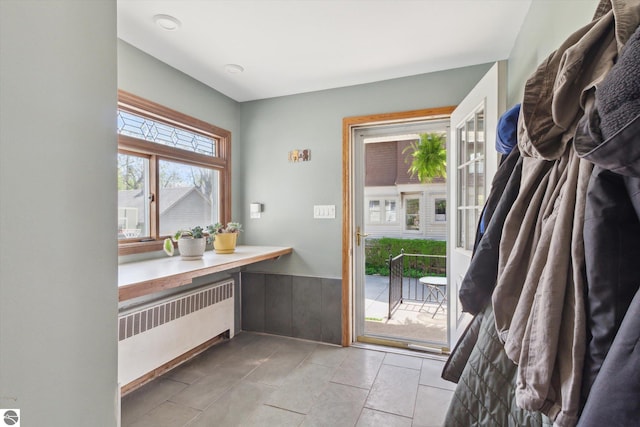 doorway featuring a wainscoted wall and radiator heating unit