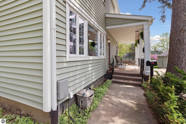 view of side of home featuring covered porch