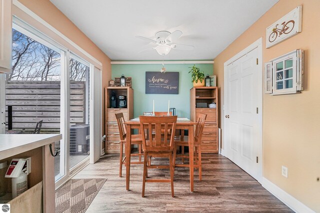 715 Lake Ave Unit 17-C, Traverse City, MI 49684 - dining room featuring ceiling fan, baseboards, and wood finished floors