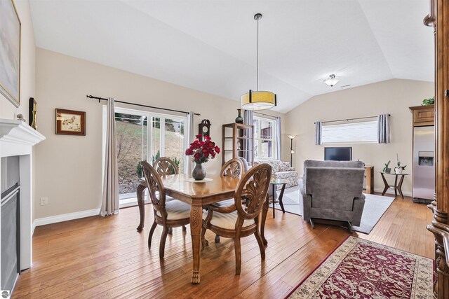 4620 Black Bear Dr Unit 49, Traverse City, MI 49685 - dining space featuring baseboards, light wood-style flooring, plenty of natural light, and vaulted ceiling