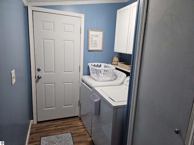 clothes washing area with cabinet space, washing machine and clothes dryer, and dark wood-style flooring