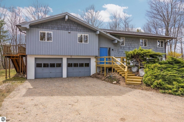 8822 Bahle Rd, Suttons Bay, MI 49682 - bi-level home with an attached garage, driveway, a deck, and stairs