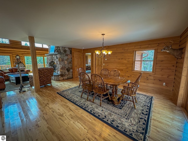 9184 S M-37, Wellston, MI 49689 - dining area with a chandelier, wood walls, and hardwood / wood-style floors
