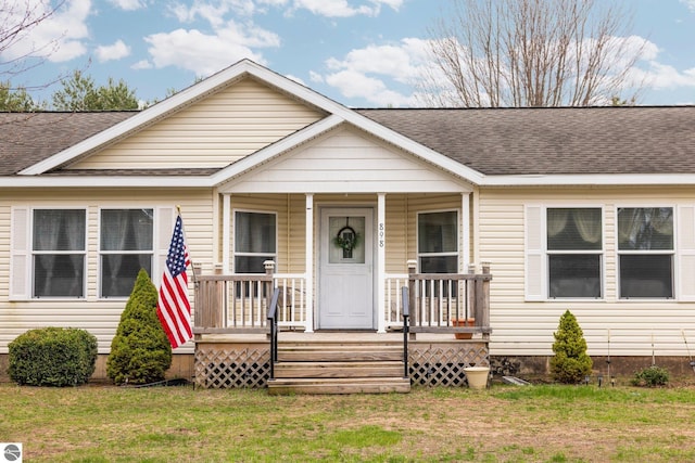 898 Leya Ln, Beulah, MI 49617 - view of front of home with covered porch, a shingled roof, and a front yard