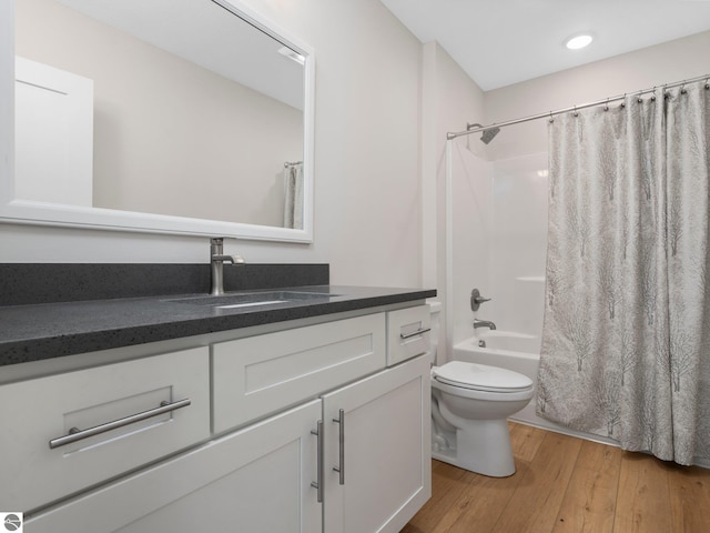 full bathroom with wood finished floors, vanity, toilet, shower / tub combo with curtain, and recessed lighting