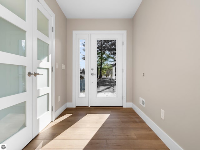 doorway to outside featuring french doors, wood finished floors, and baseboards