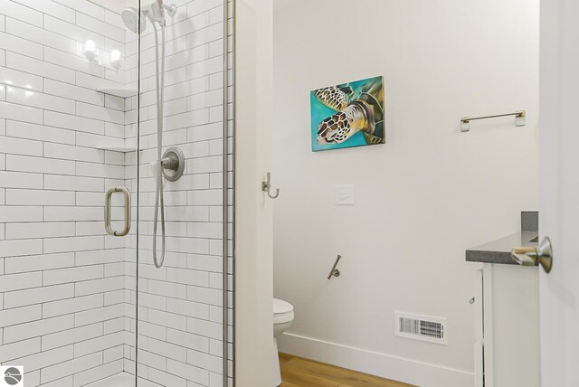 8906-B Manhattan N Unit B, Traverse City, MI 49685 - bathroom with a stall shower, wood finished floors, toilet, and baseboards