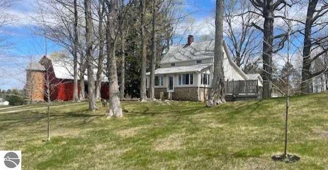 3312 Zimmerman Rd, Traverse City, MI 49685 - view of grassy yard with a barn, an outbuilding, and a deck