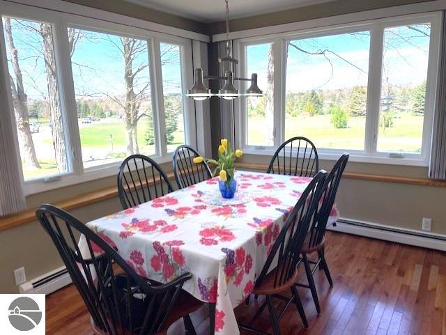 3312 Zimmerman Rd, Traverse City, MI 49685 - dining space featuring a baseboard radiator, wood finished floors, and a chandelier