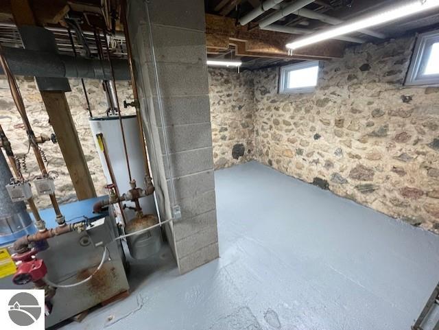 3312 Zimmerman Rd, Traverse City, MI 49685 - below grade area featuring healthy amount of natural light and water heater