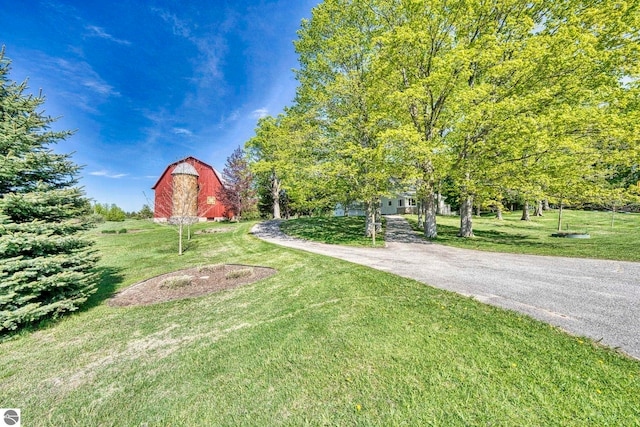 3312 Zimmerman Rd, Traverse City, MI 49685 - view of grassy yard featuring a barn, an outbuilding, and driveway