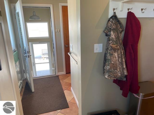 3312 Zimmerman Rd, Traverse City, MI 49685 - doorway to outside with light tile patterned floors, healthy amount of natural light, and baseboard heating