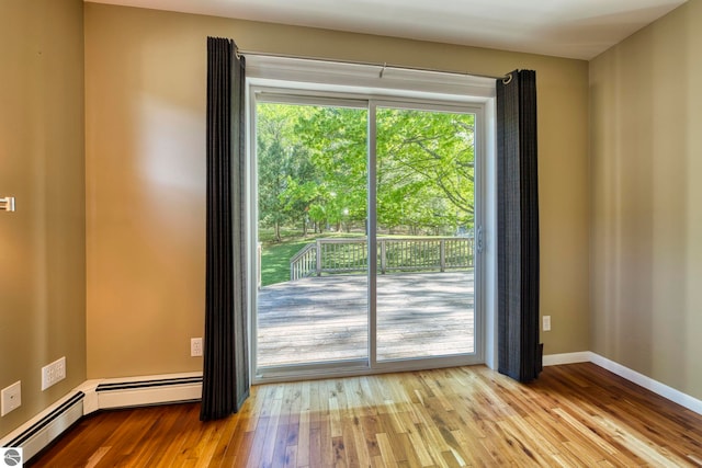 3312 Zimmerman Rd, Traverse City, MI 49685 - spare room with healthy amount of natural light, wood finished floors, baseboards, and a baseboard radiator