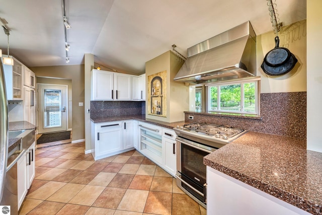 3312 Zimmerman Rd, Traverse City, MI 49685 - kitchen with wall chimney range hood, stainless steel gas range, track lighting, vaulted ceiling, and white cabinets