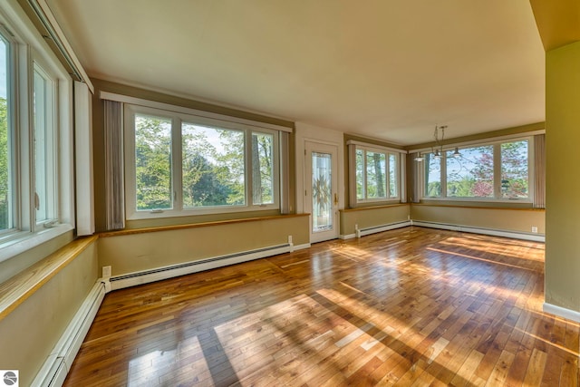 3312 Zimmerman Rd, Traverse City, MI 49685 - empty room featuring hardwood / wood-style flooring, healthy amount of natural light, a baseboard heating unit, and baseboard heating