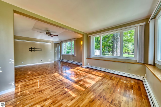 3312 Zimmerman Rd, Traverse City, MI 49685 - unfurnished room featuring baseboard heating, a baseboard radiator, wood-type flooring, vaulted ceiling, and ceiling fan